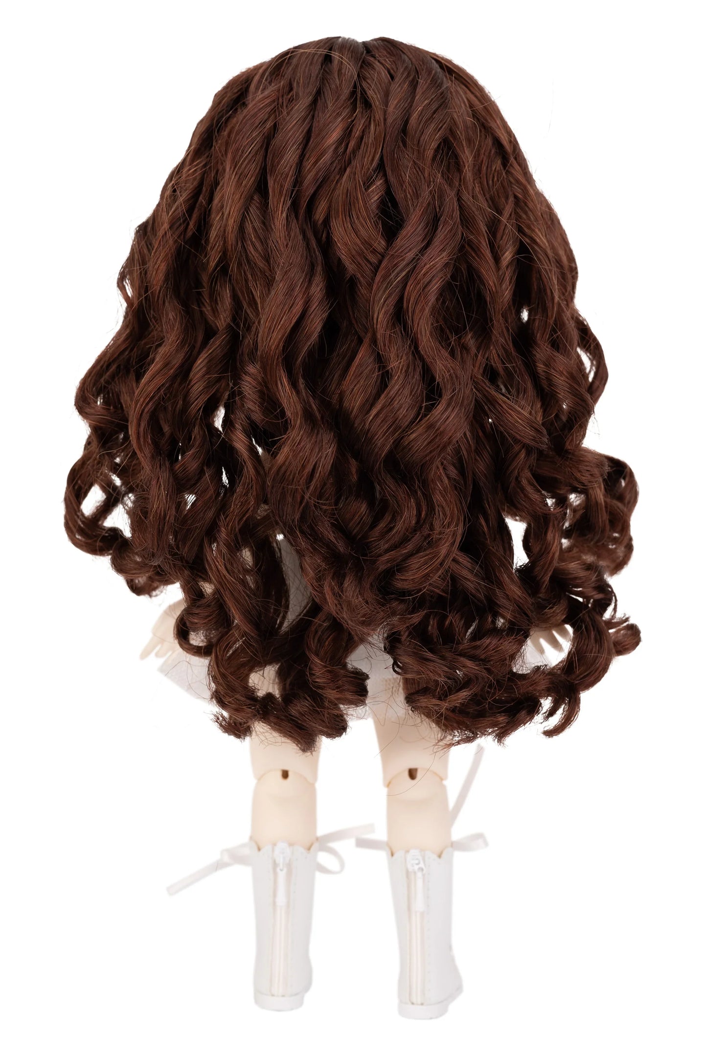 Brown wig on a doll head against a white background