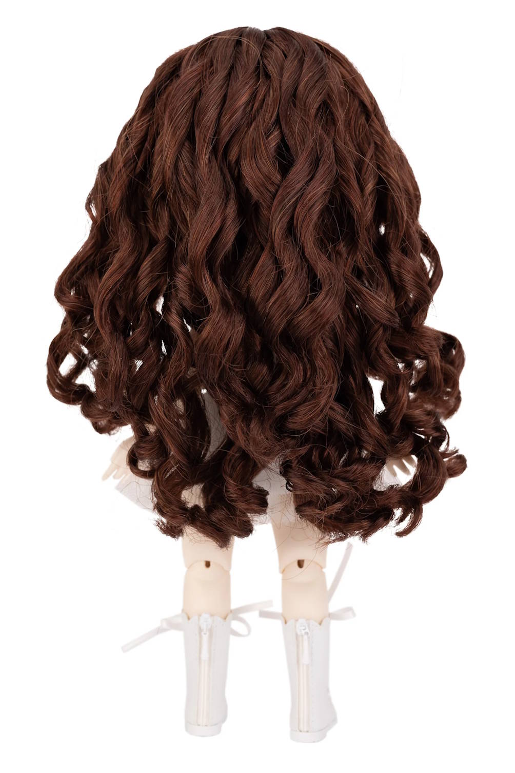 Brown wig on a doll head against a white background