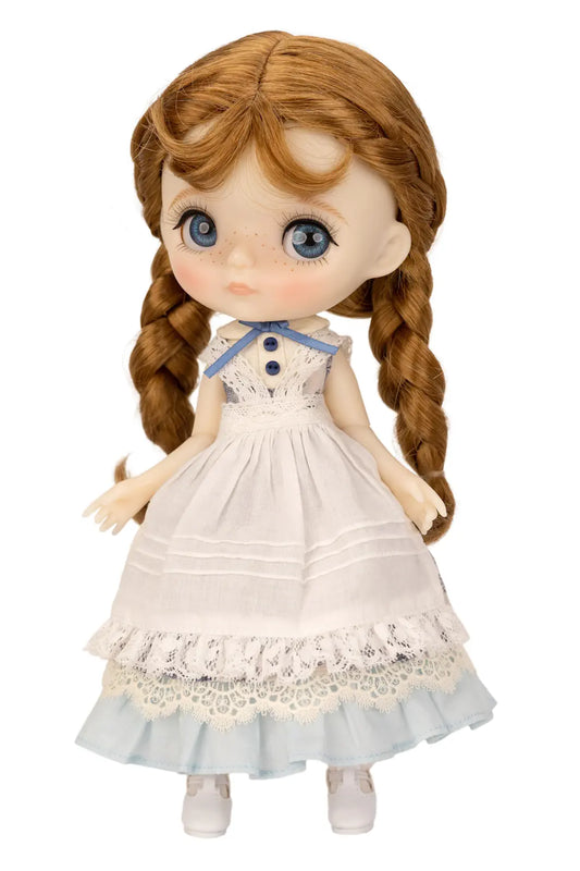 Doll with braided hair wearing a white dress with lace details on a white background