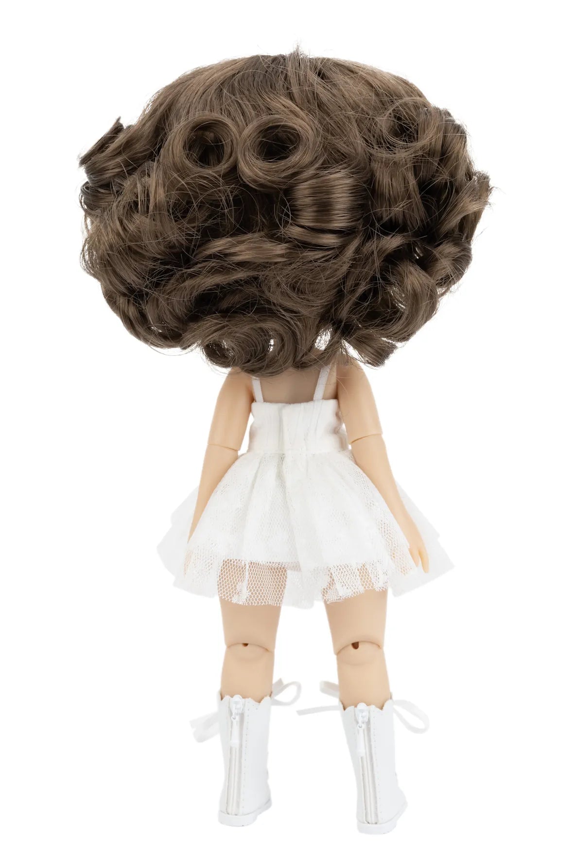 Doll with a large brown wig and white outfit on a white background