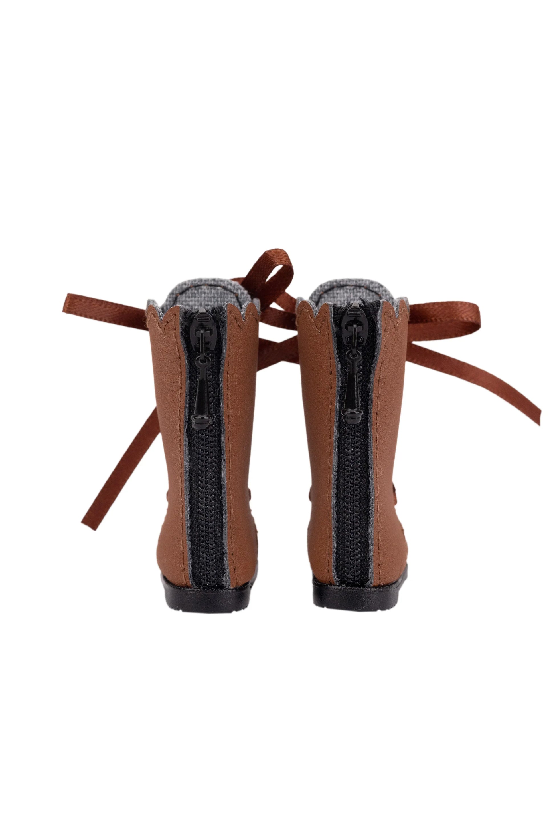 Pair of brown boots with zippers at the back on a white background