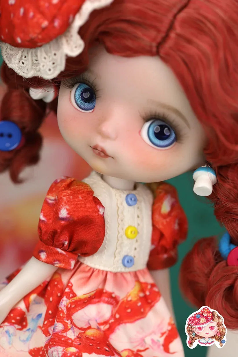 Close-up of a Mori Lolli Mushroom Fantasia doll with red hair and blue eyes wearing a red dress with colorful buttons.