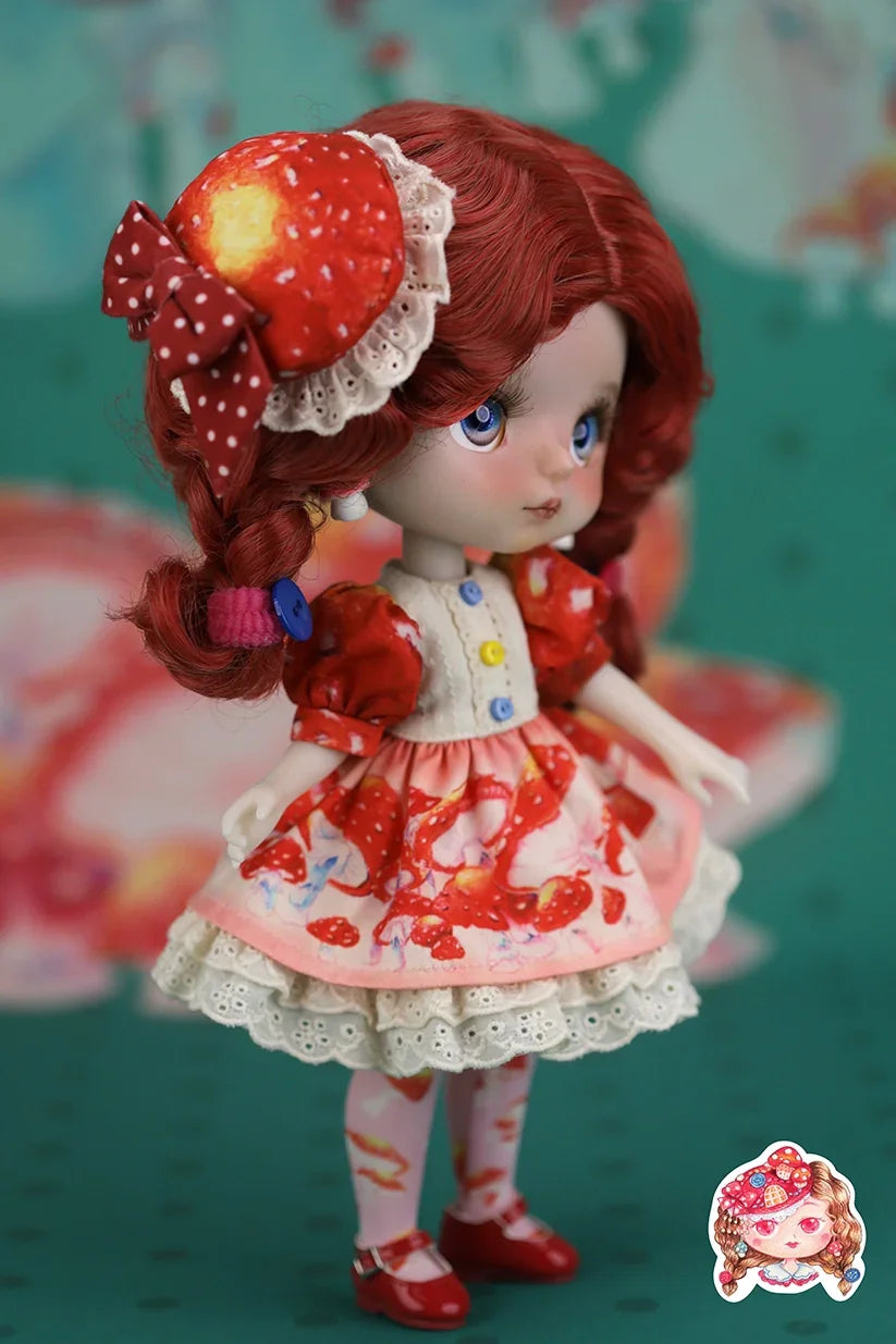 Mori Lolli Doll with red hair and a colorful outfit against a teal background