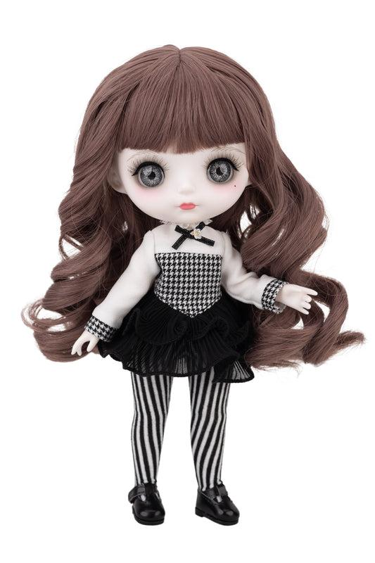 Doll with long brown hair and a black and white outfit on a white background