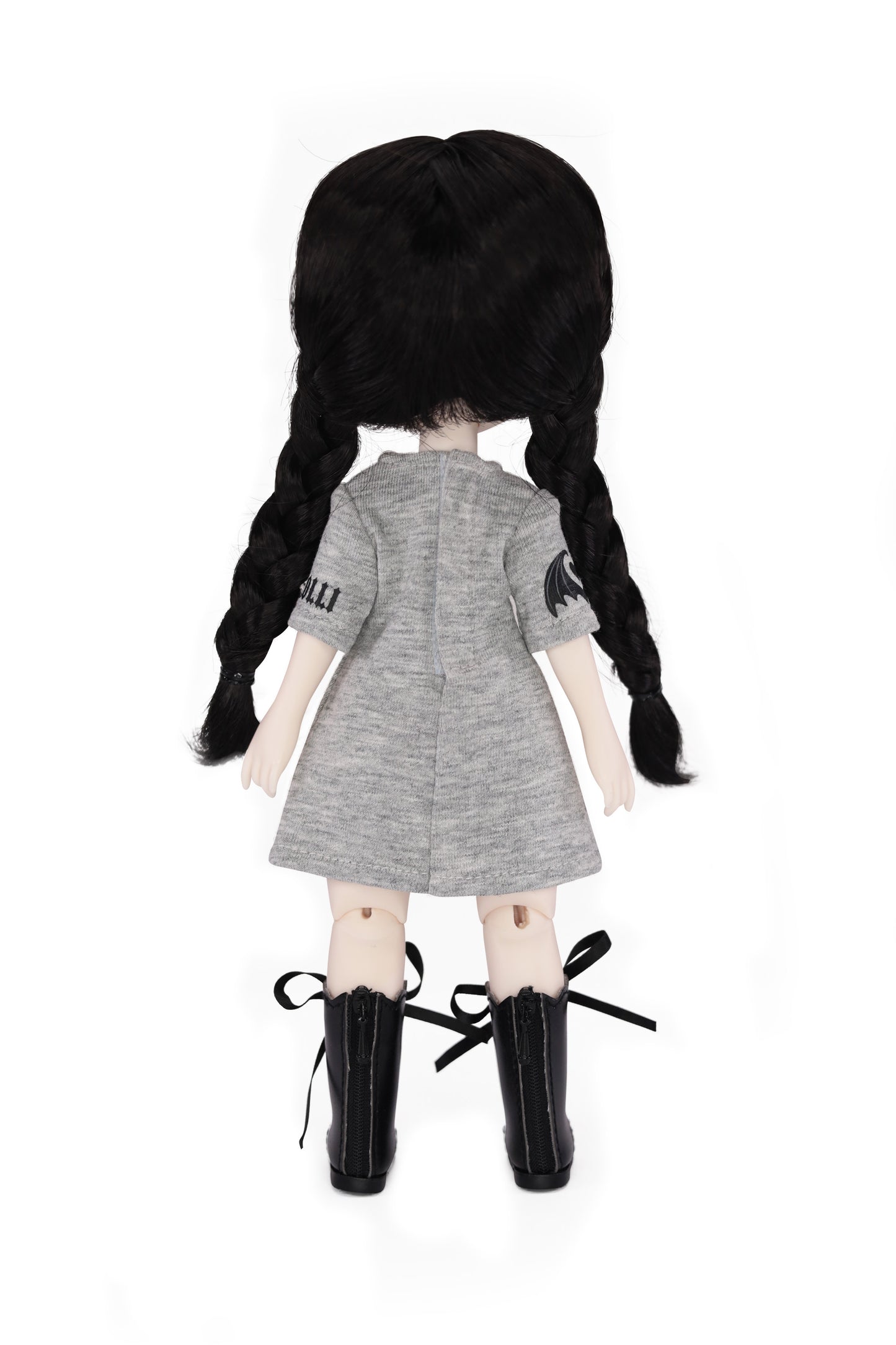 Doll with black pigtails wearing a gray dress and black boots on a white background