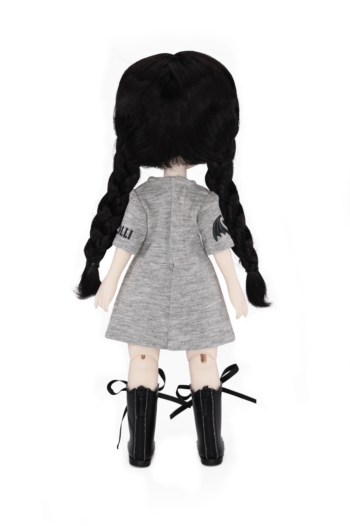 Doll with black pigtails wearing a gray dress and black boots on a white background