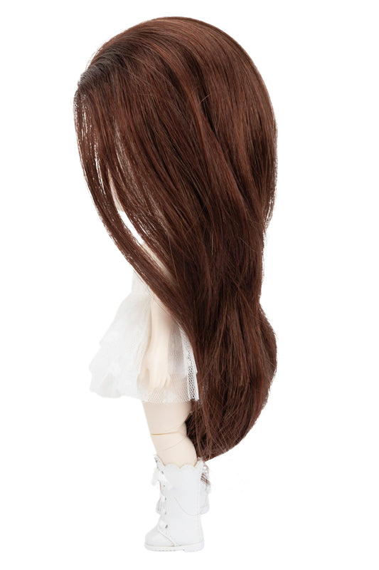 Brown wig on a doll head with a white background