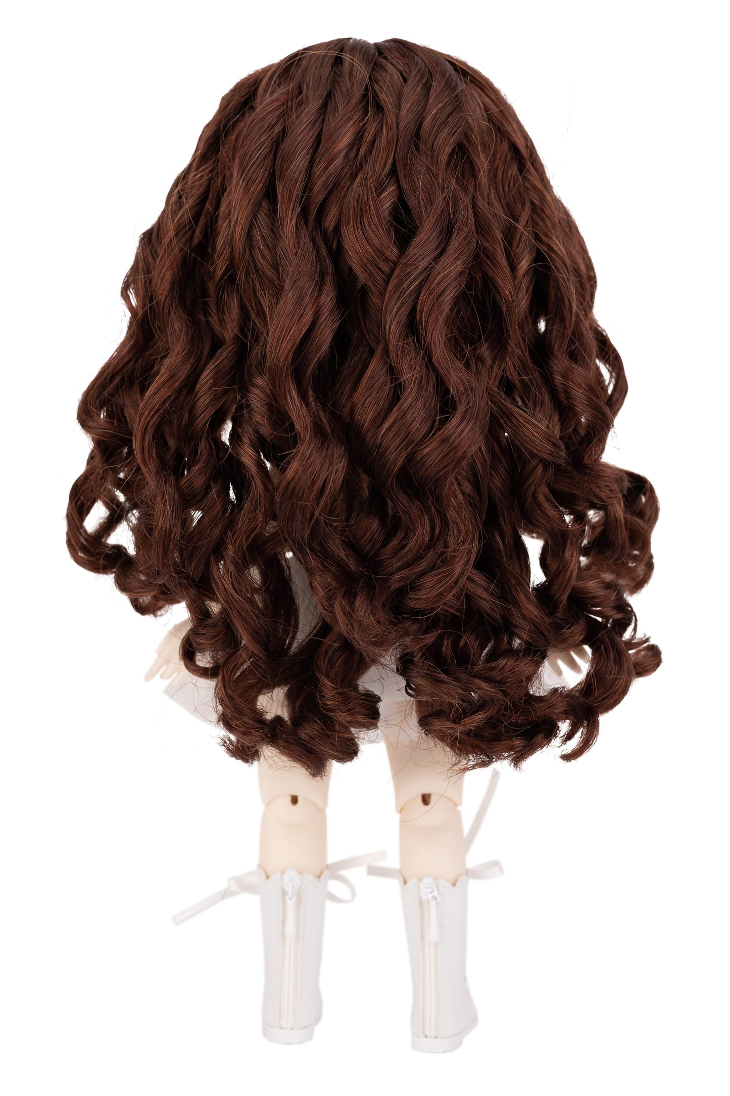 Brown wig on a doll head against a white background