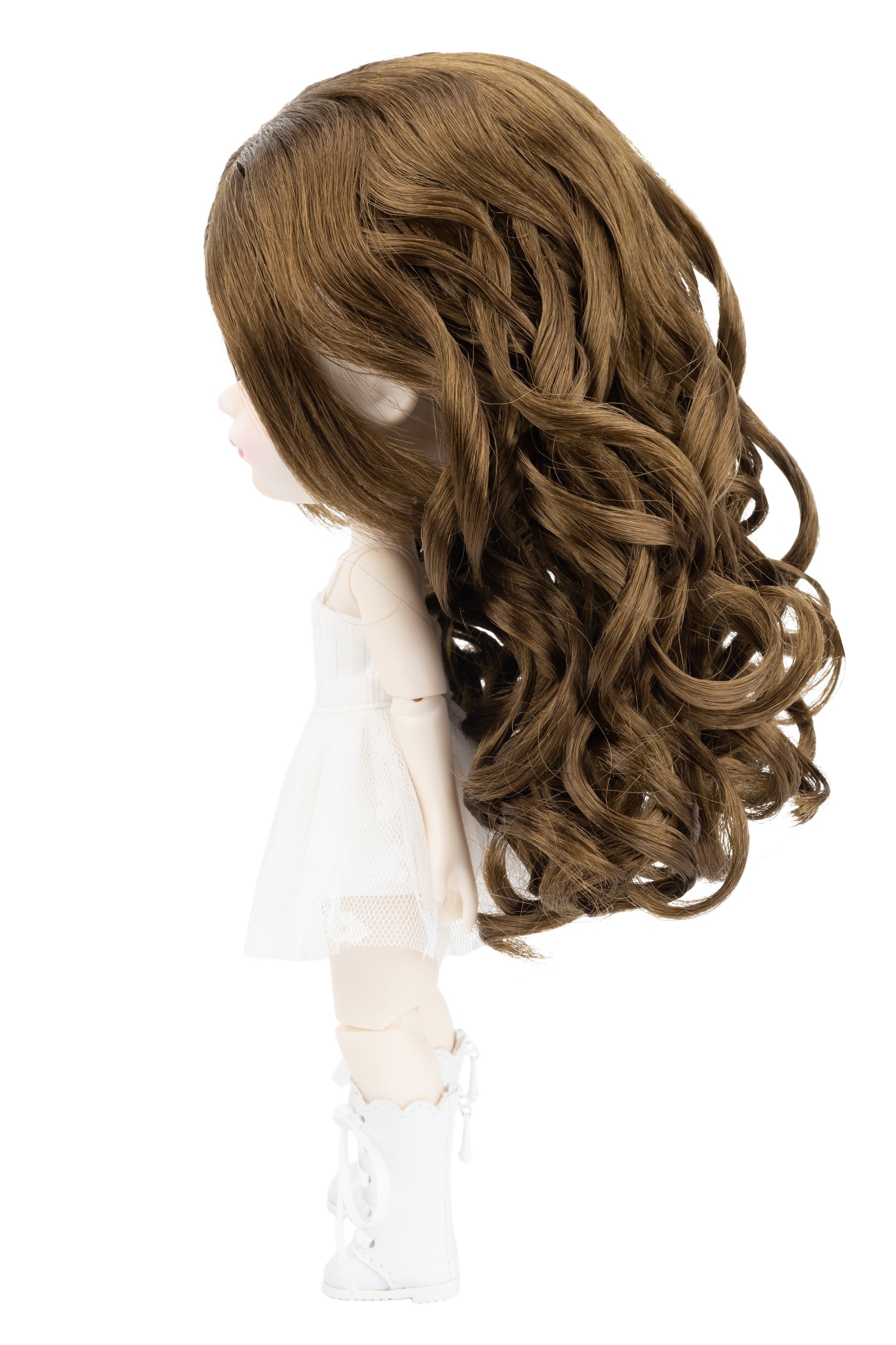 Brown wig on a doll head against a white background