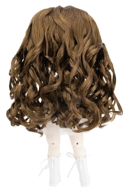 Brown wavy wig on a doll head against a white background