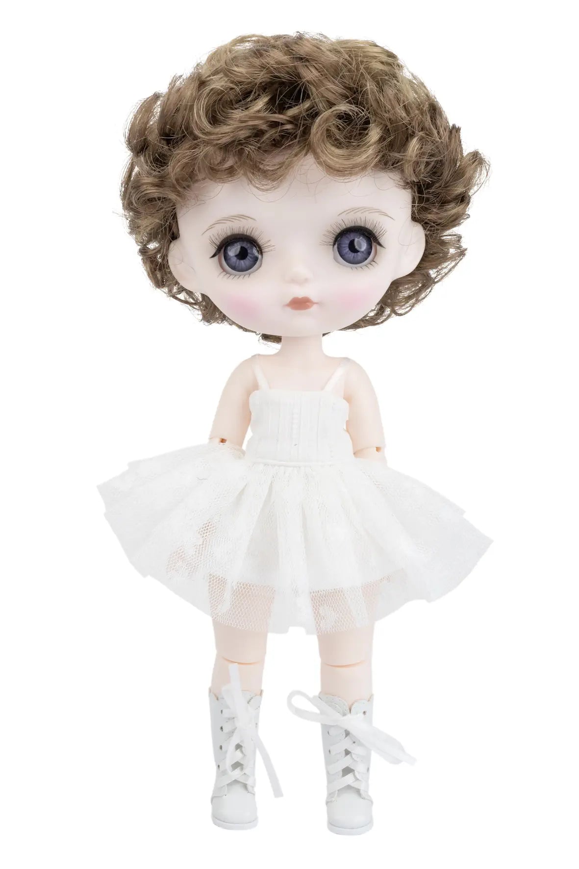 A doll with large blue eyes, brown curly hair, and a white tutu dress, standing against a plain white background.
