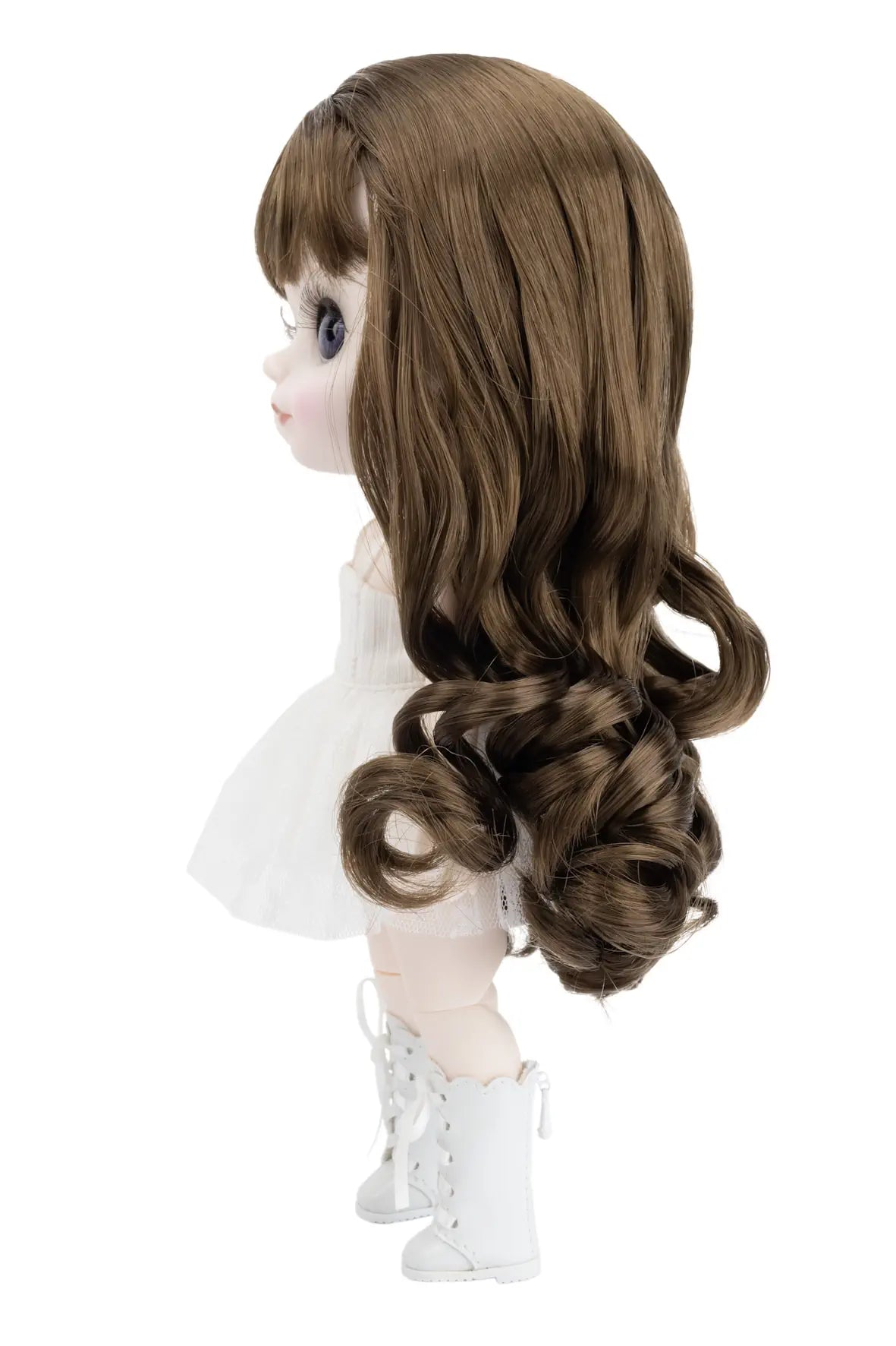 Brunette wig on a doll with a white dress and boots against a white background