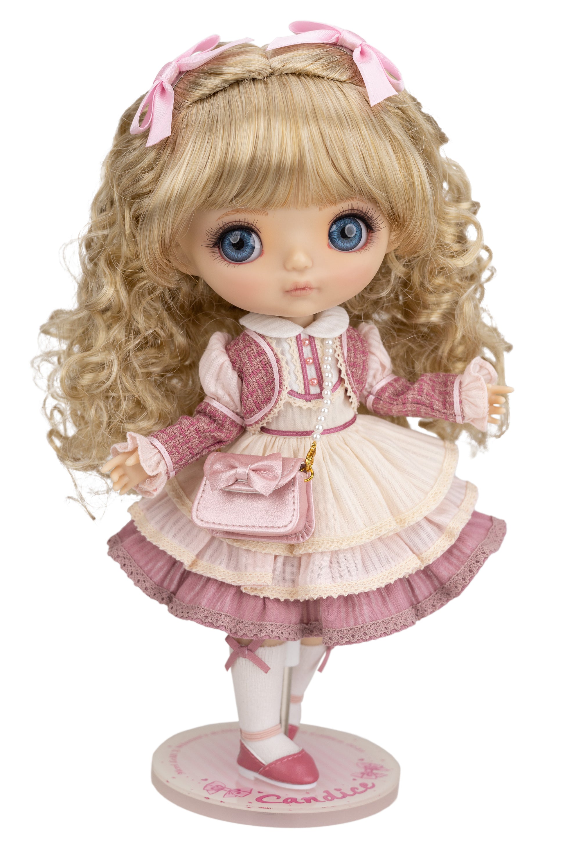 Candice doll with blonde hair and blue eyes wearing a pink and white outfit on a white background