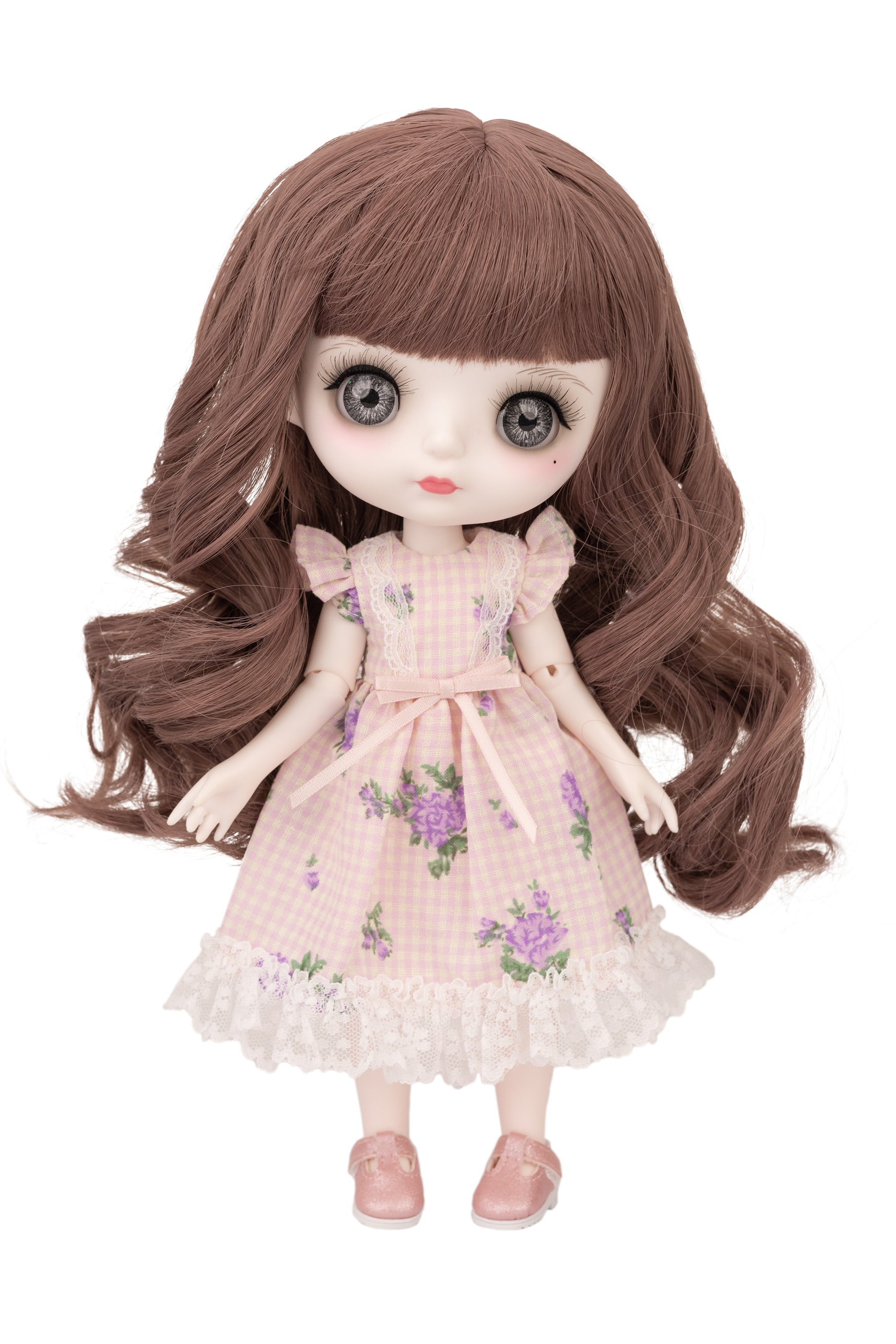Doll with long brown hair wearing a pink floral dress on a white background