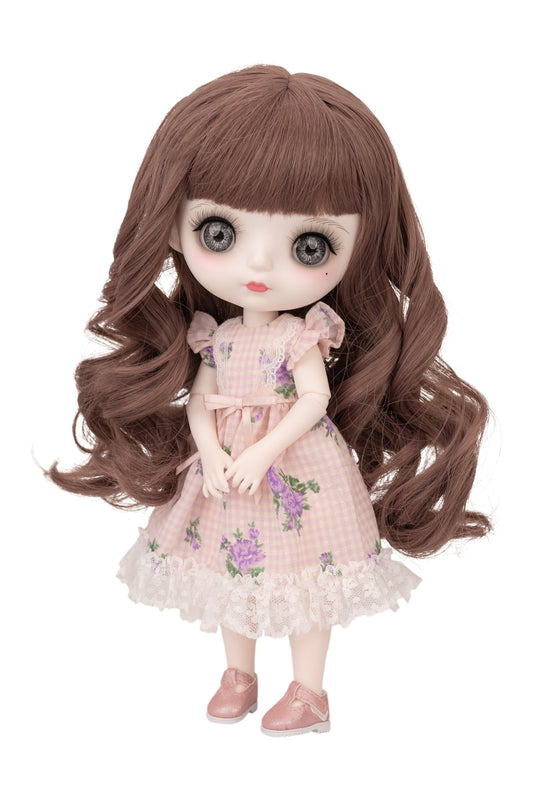Doll with long brown hair and a pink floral dress on a white background