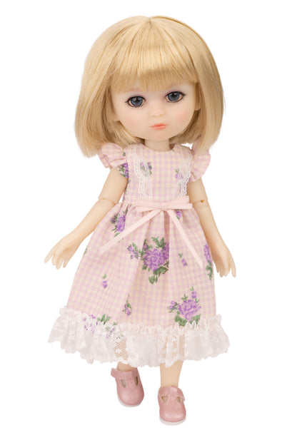 Doll with blonde hair wearing a pink floral dress on a white background