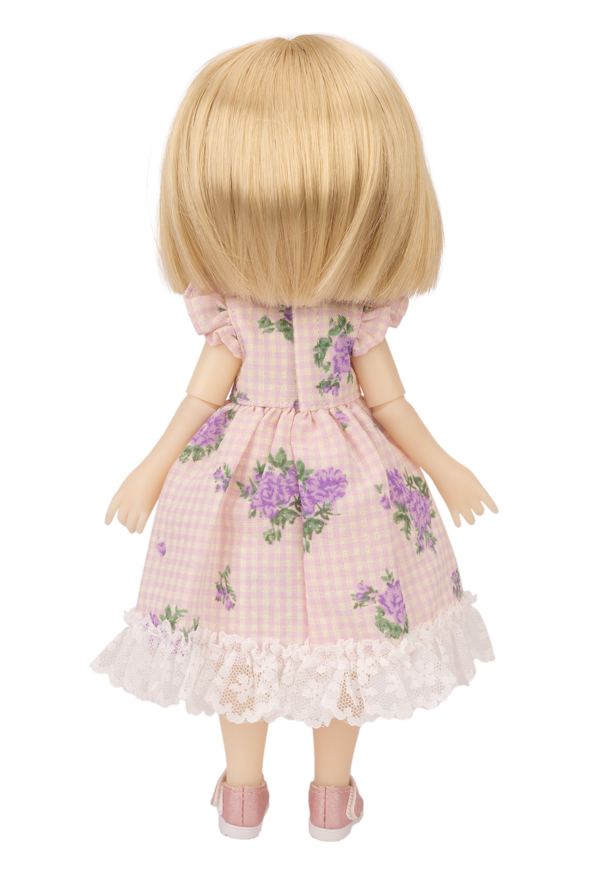 Doll wearing a pink floral dress on a white background