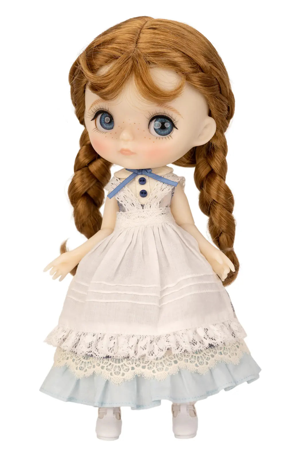 Doll with braided hair wearing a white dress with lace details on a white background