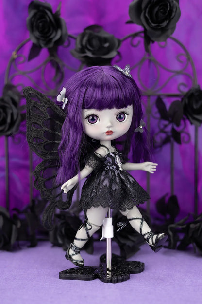 Gothic-style doll with purple hair and black outfit against a purple background with black roses.
