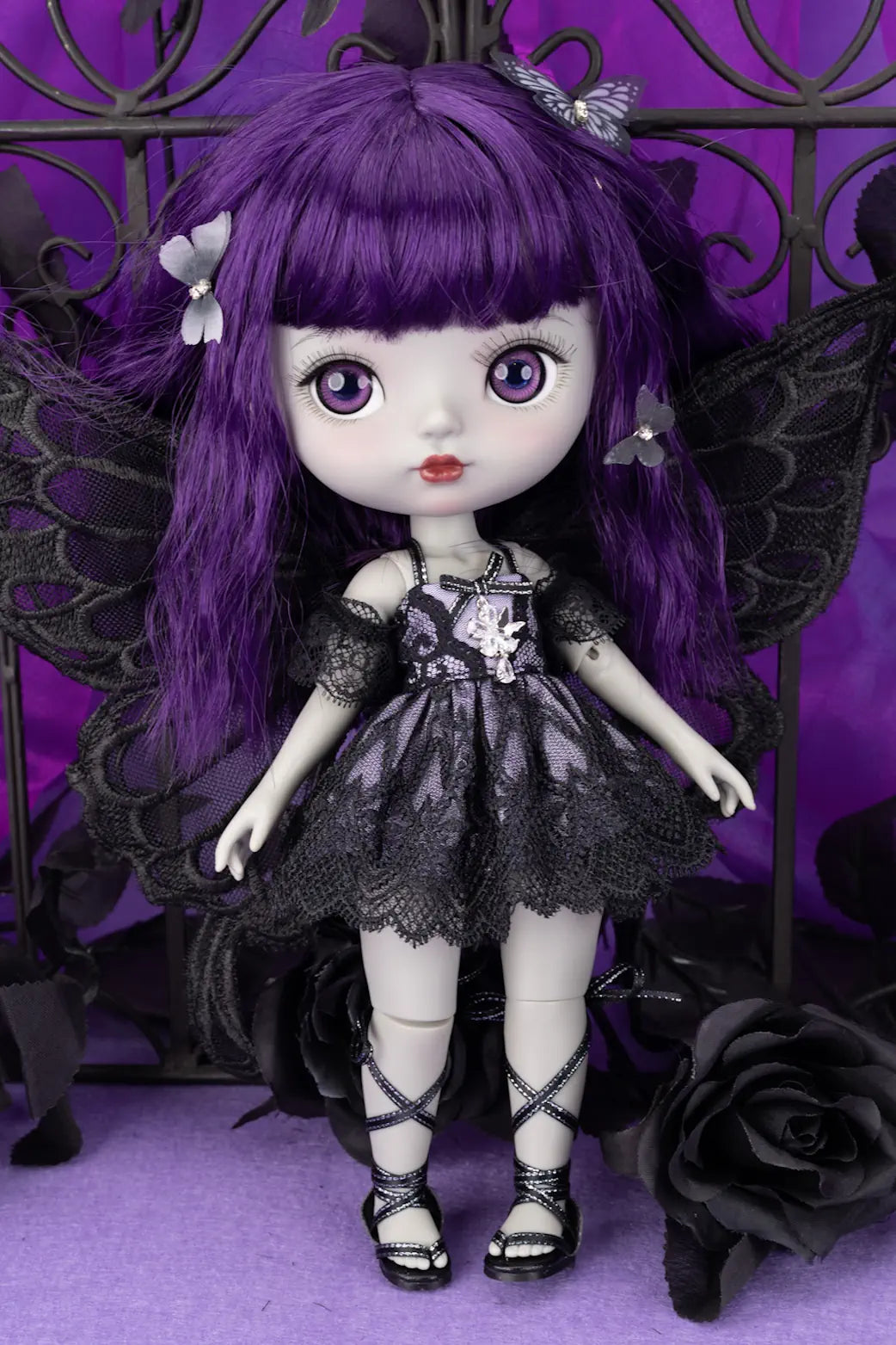 Doll with purple hair and black outfit against a purple background