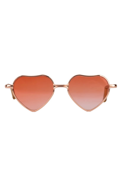 Heart-shaped sunglasses with rose gold frame and red lenses on a white background