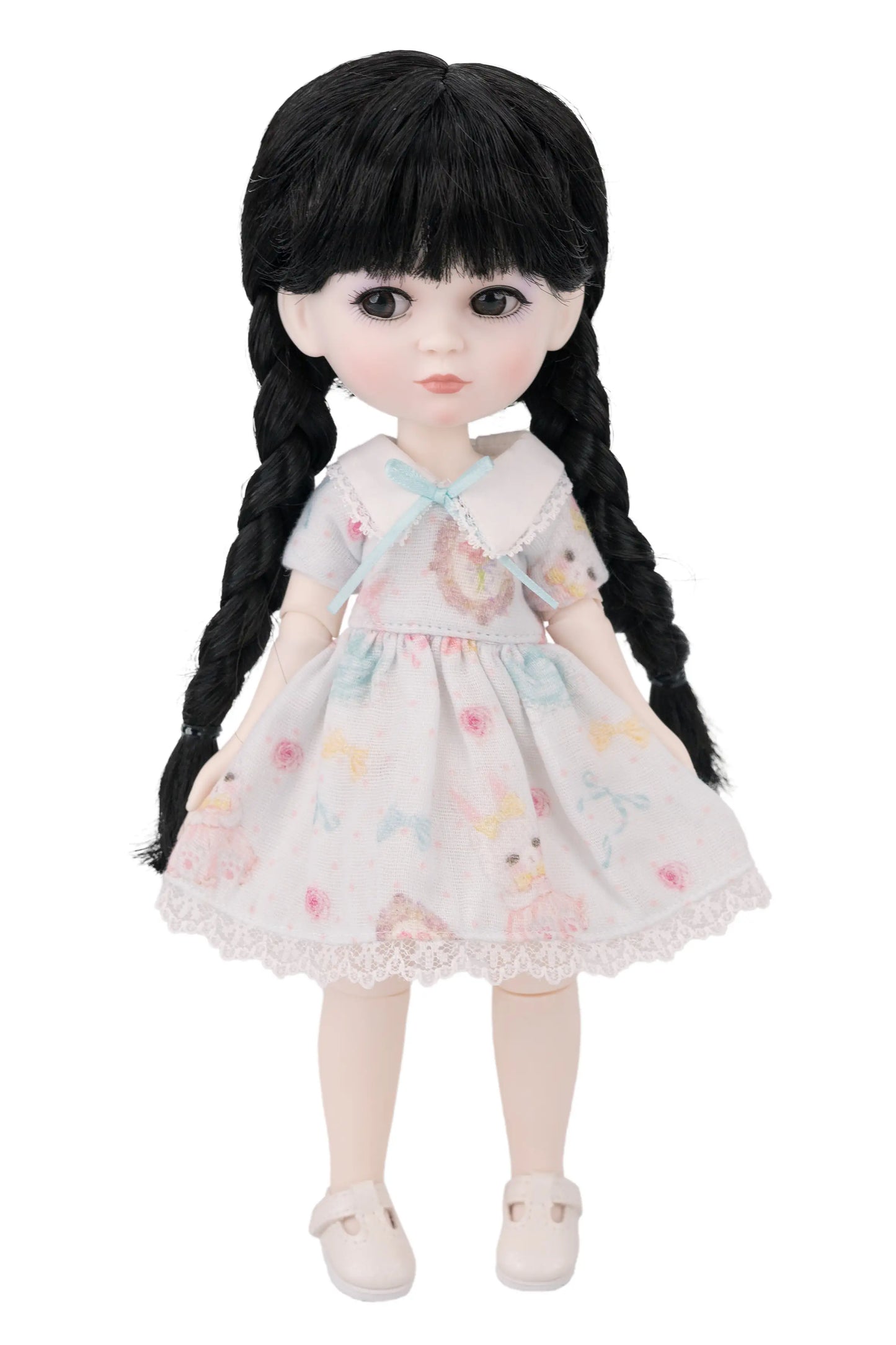 Doll with long black hair and a floral dress on a white background