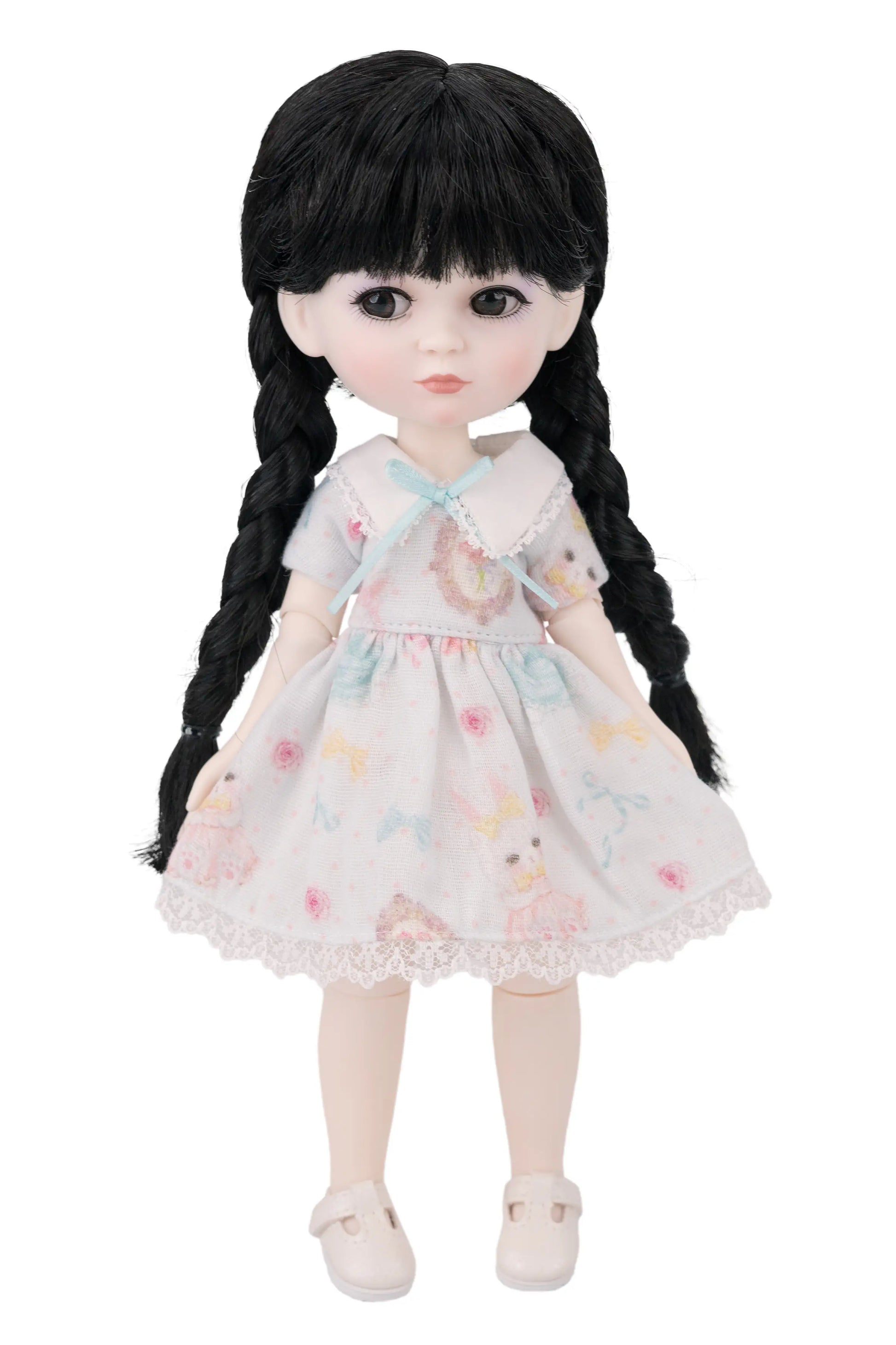 Doll with long black hair and a floral dress on a white background