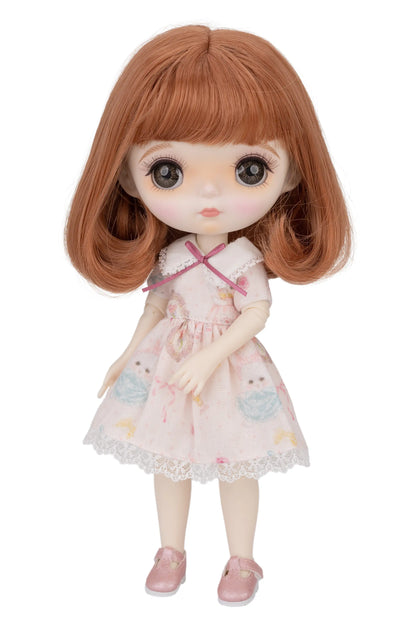 Doll with brown hair and a pink dress on a white background