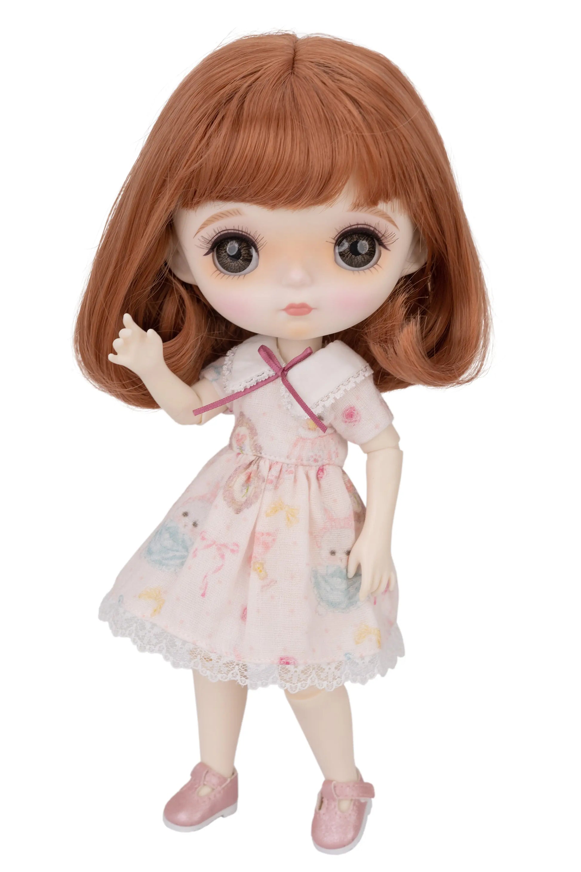 Doll with brown hair and a pink dress on a white background