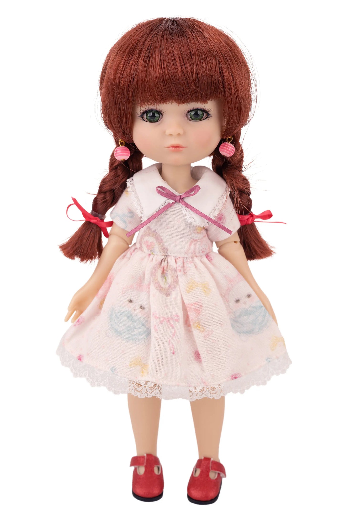 Doll with red hair styled in pigtails, wearing a pink dress with bunny patterns on a white background.