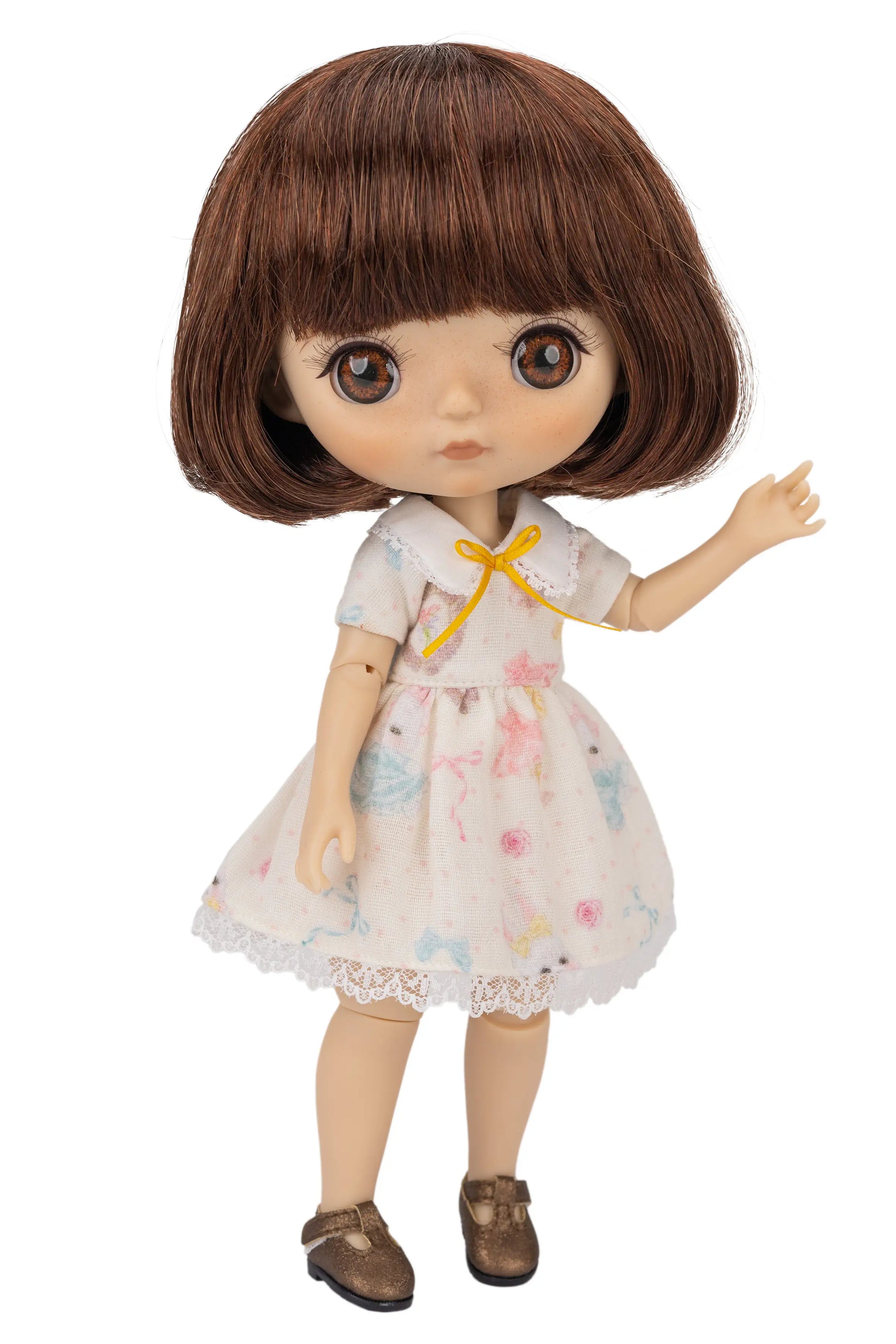 Doll with brown hair wearing a floral dress on a white background