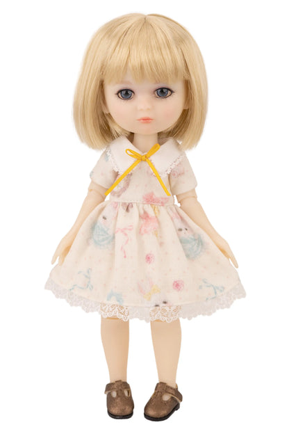 Doll with blonde hair and a floral dress on a white background