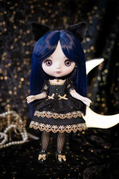 A doll with long dark blue hair, black cat ears, and a black dress with gold lace trim, posed against a dark starry backdrop with a crescent moon and pearl beads.