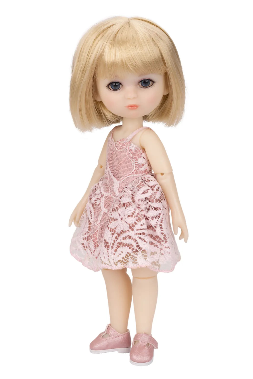 A Luna Lily doll with blue eyes wearing a pink lace dress and pink shoes, standing against a plain white background.