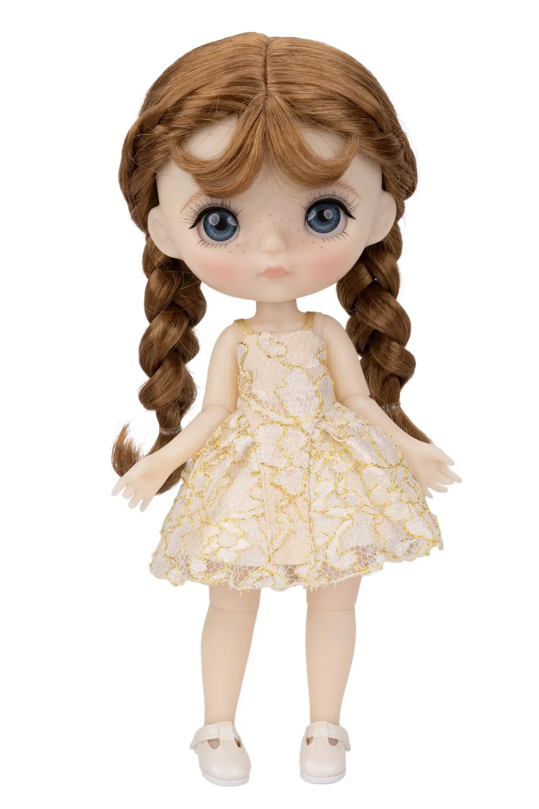 A doll with large blue eyes, long auburn hair in two braids, and a cream-colored dress with a gold floral pattern, standing against a plain white background.