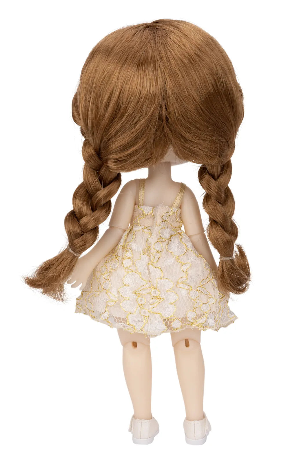 A doll viewed from the back, featuring long auburn-brown braided hair and wearing a white sleeveless dress with a gold pattern and white shoes, isolated on a white background.