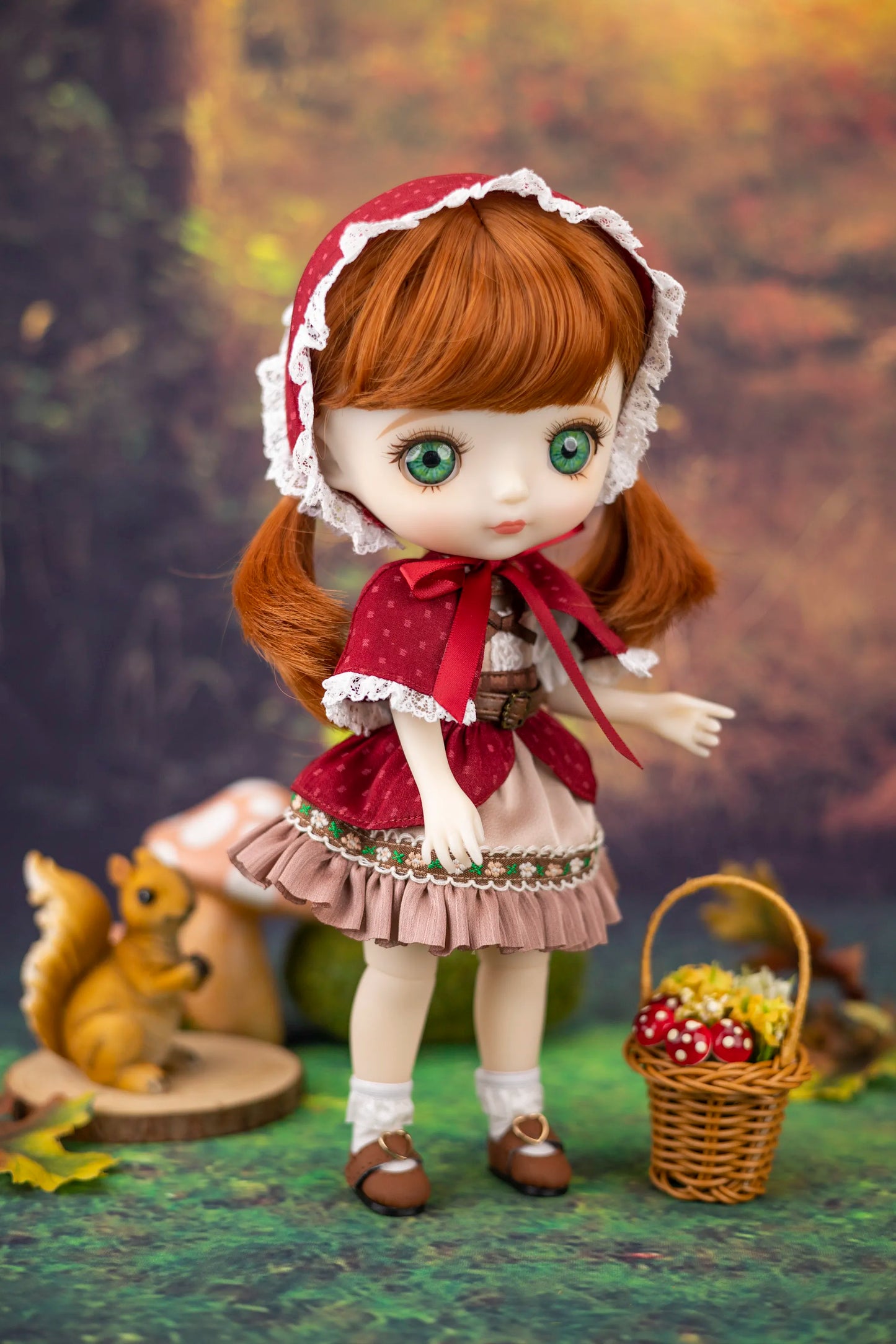 Doll with ginger hair and outfit standing next to a basket of mushrooms and a squirrel figurine.