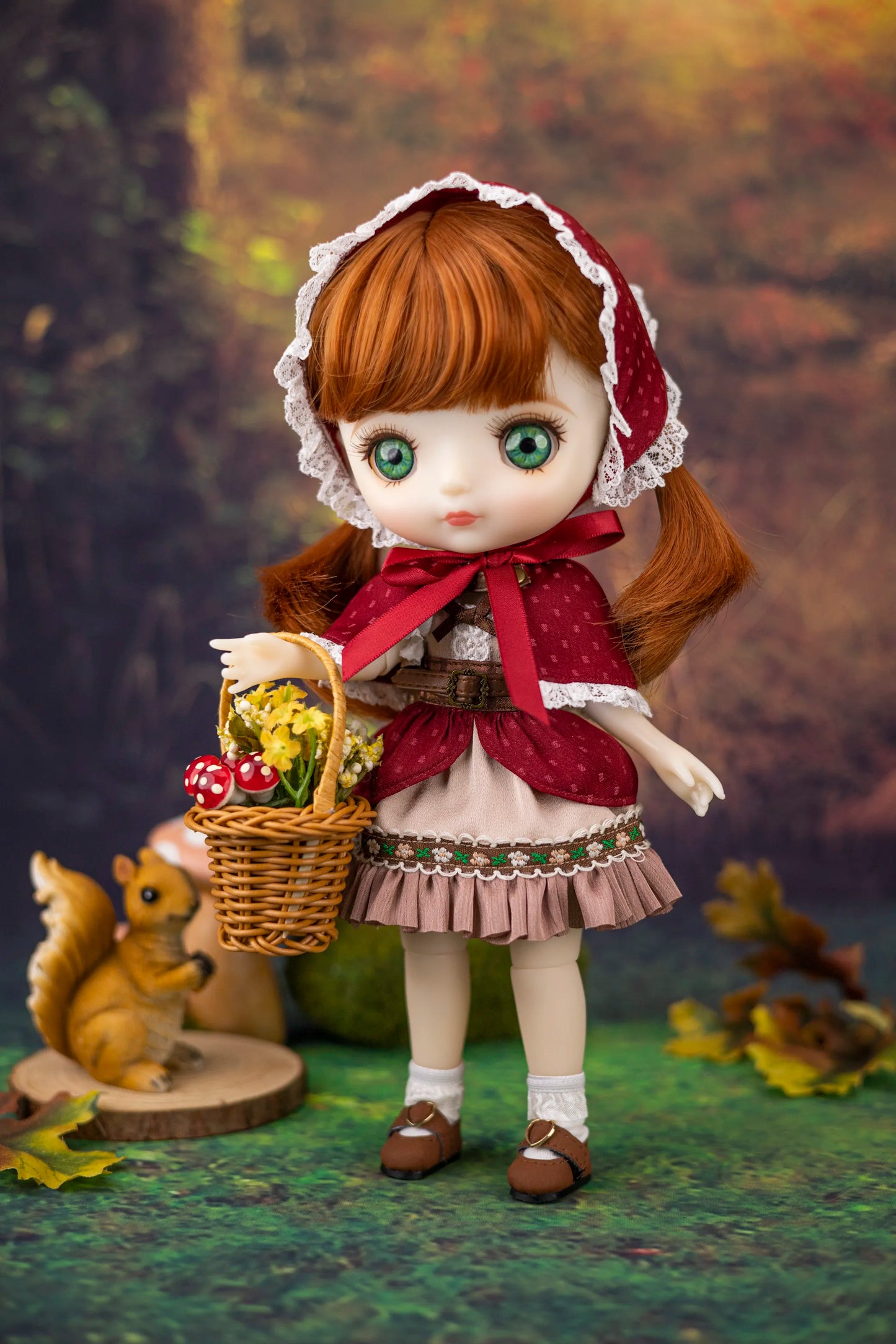 Doll in a ginger dress with a basket of apples against a natural background