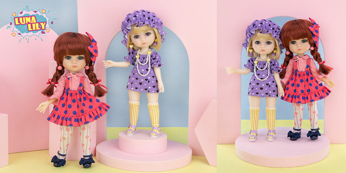 Two dolls in colorful outfits standing on pink platforms against a pastel pink background. They are Luna Lily.