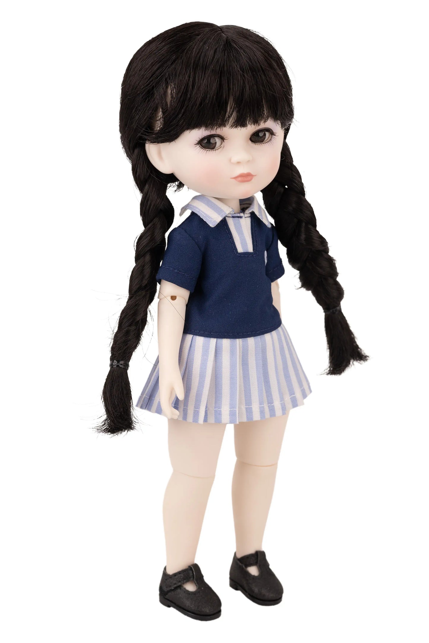 Doll with black hair styled in pigtails, wearing a blue top and striped skirt on a white background.