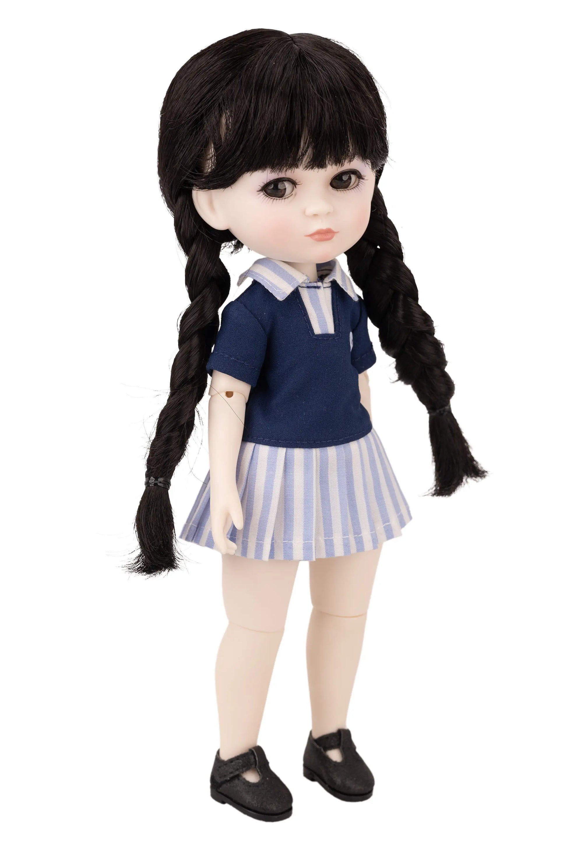 Doll with black hair styled in pigtails, wearing a blue top and striped skirt on a white background.