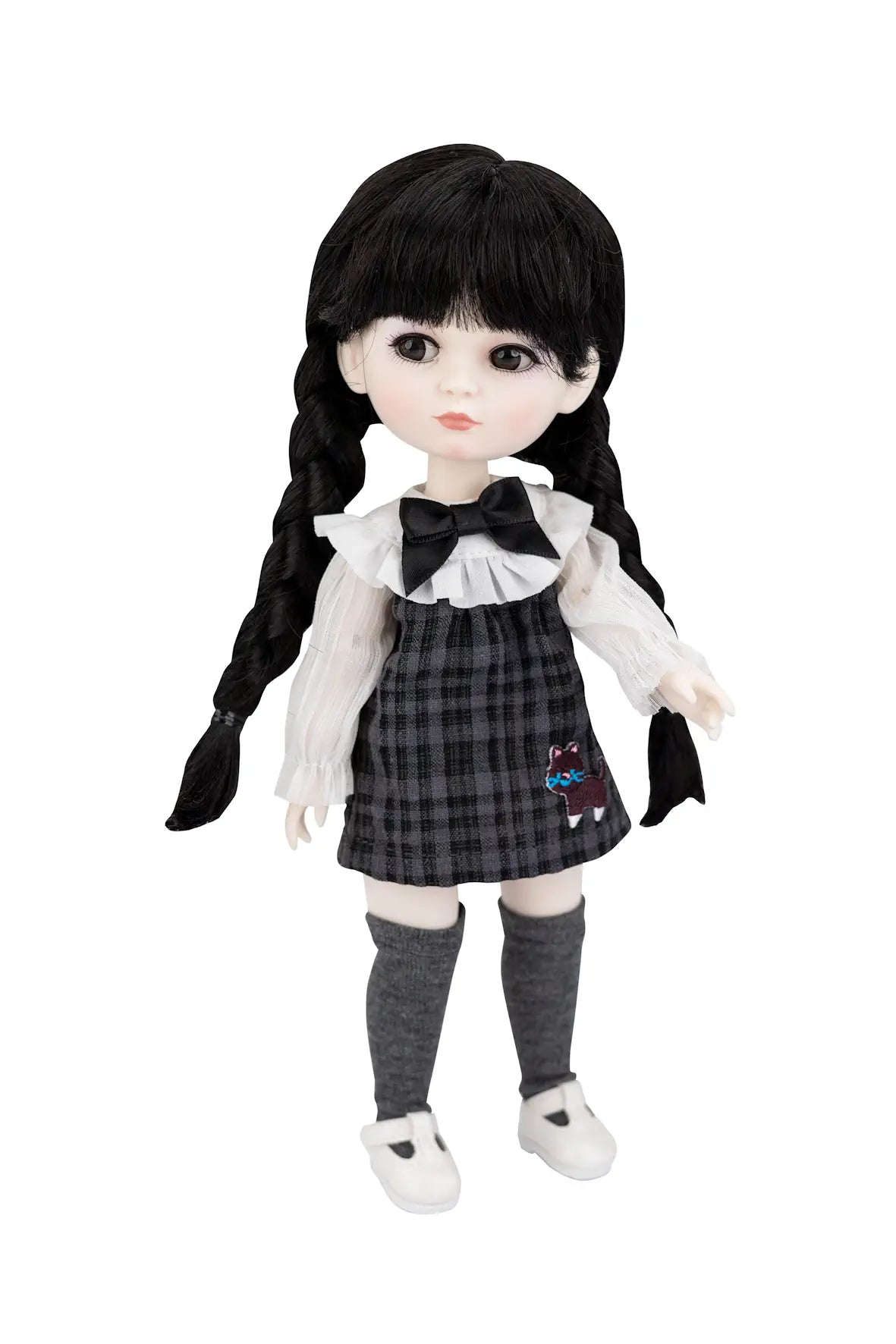 A gothic-style doll with long black braided hair, wearing a black and gray plaid dress over a white ruffled blouse, with gray socks and white shoes, set against a plain white background.