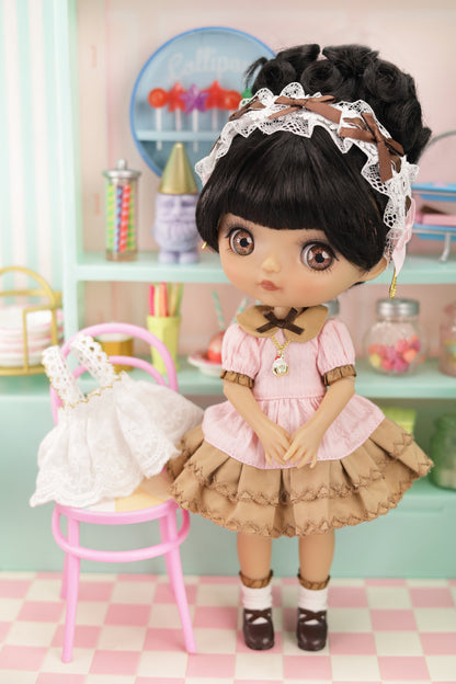 Doll in a pink dress with a checkered floor and pastel-colored room.