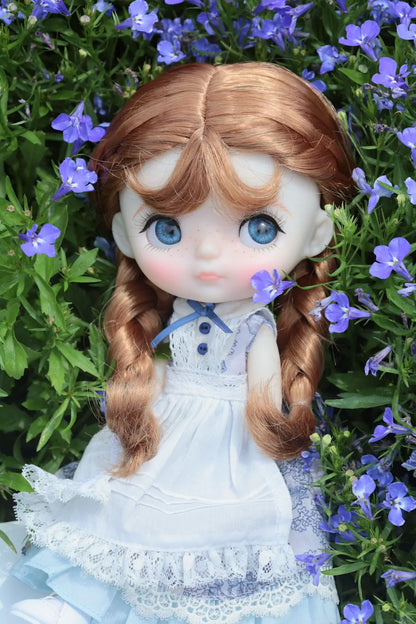 Doll with long brown hair and blue eyes surrounded by purple flowers