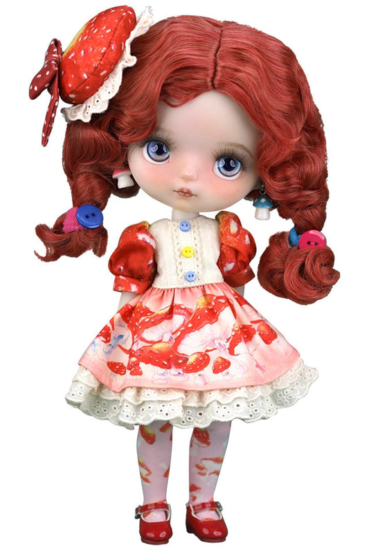 Doll with red hair styled in pigtails, wearing a strawberry-themed outfit on a white background