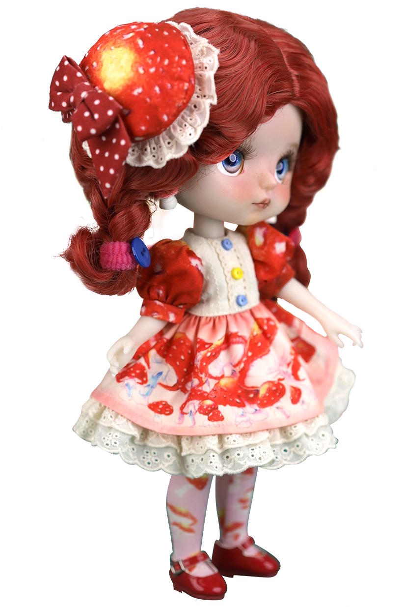 Doll with red hair and a red dress on a white background