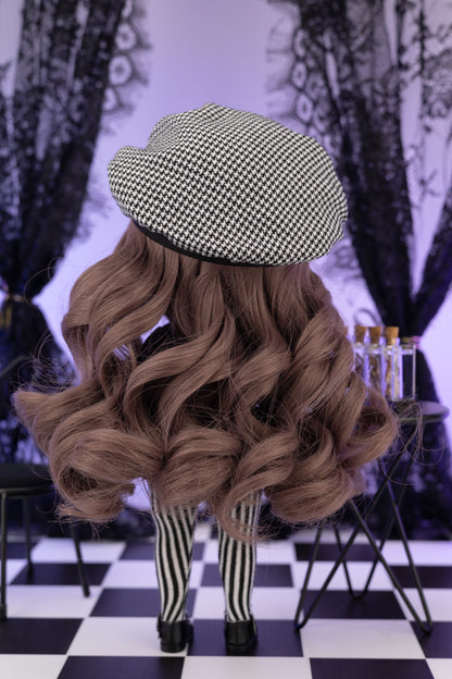 Person wearing a checkered beret, long wavy hair, and striped pants on a black and white checkered floor.