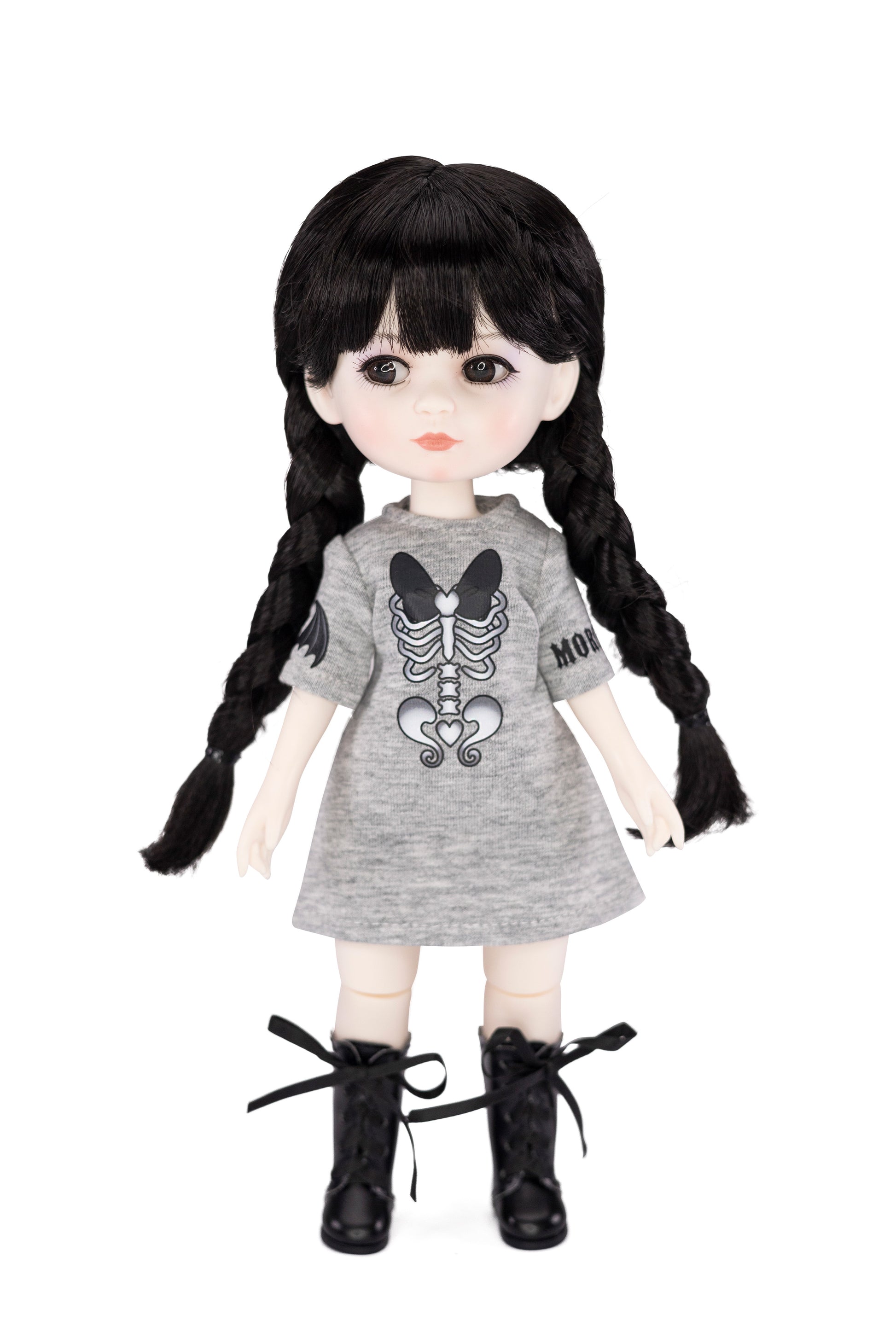 Doll with black hair in pigtails wearing a gray dress with a skeleton design on a white background
