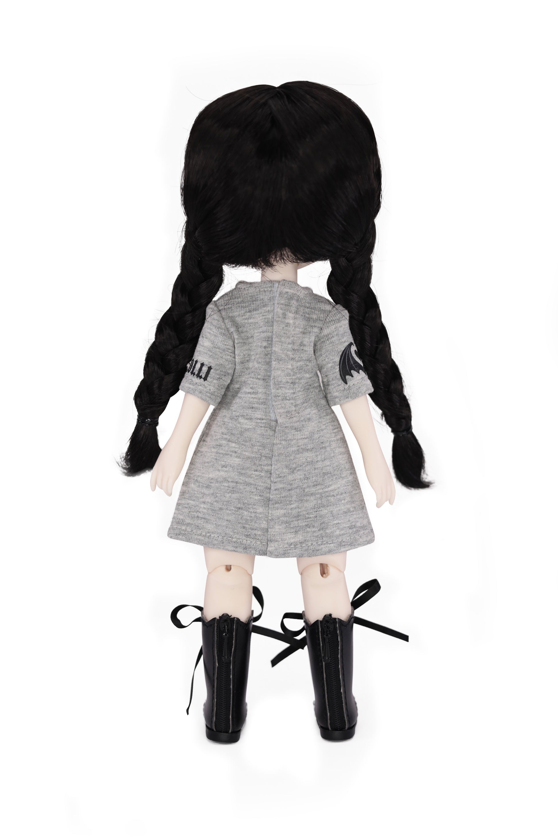 Doll with black pigtails wearing a gray dress and black boots on a white background