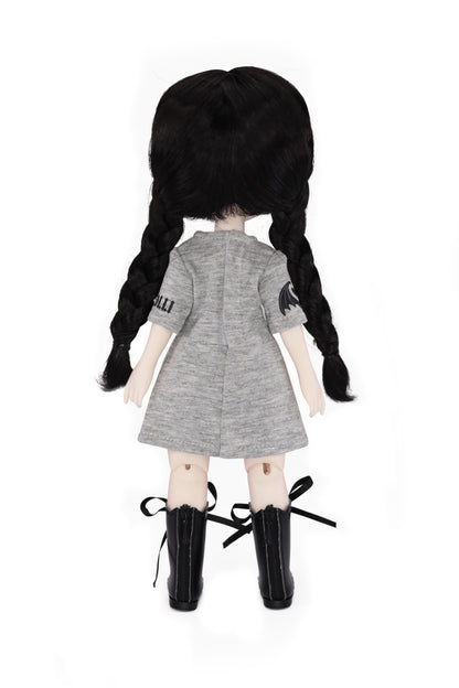 Doll with black pigtails wearing a gray dress and black boots on a white background